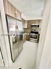 17570 Atlantic Blvd Unit 119, Sunny Isles Beach, FL 33160 - kitchen with stainless steel appliances and brown cabinetry