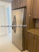 17570 Atlantic Blvd Unit 119, Sunny Isles Beach, FL 33160 - kitchen featuring freestanding refrigerator and light stone countertops