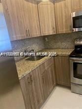 17570 Atlantic Blvd Unit 119, Sunny Isles Beach, FL 33160 - kitchen with stainless steel appliances, light stone counters, and backsplash