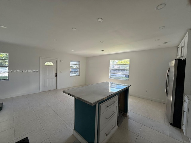 9801 SW 56th St, Miami, FL 33165 - kitchen with freestanding refrigerator, light tile patterned flooring, a kitchen island, white cabinetry, and recessed lighting