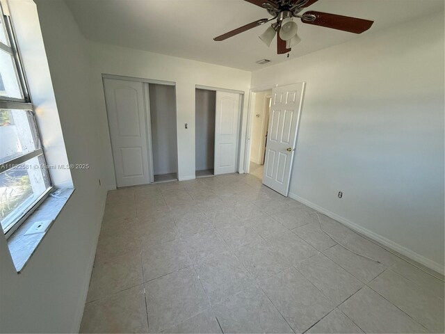 9801 SW 56th St, Miami, FL 33165 - unfurnished bedroom with multiple closets, light tile patterned floors, and ceiling fan