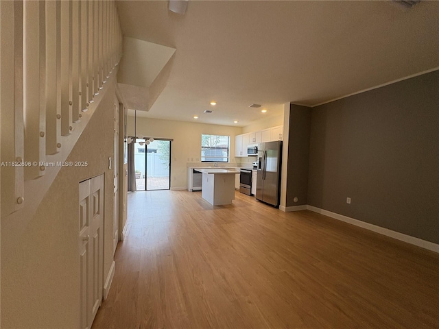 10586 W 33rd Ct Unit 10586, Hialeah, FL 33018 - kitchen with appliances with stainless steel finishes, light wood-style floors, white cabinetry, recessed lighting, and a kitchen island