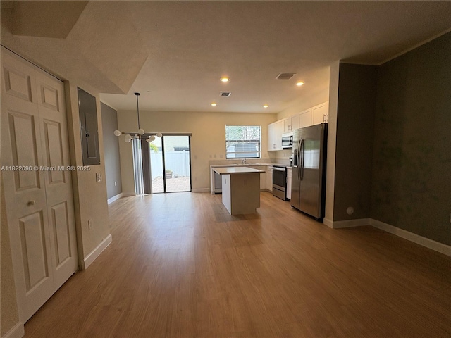 10586 W 33rd Ct Unit 10586, Hialeah, FL 33018 - kitchen featuring stainless steel appliances, white cabinets, electric panel, a chandelier, and light wood finished floors