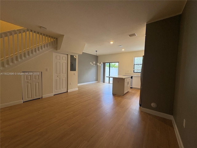 10586 W 33rd Ct Unit 10586, Hialeah, FL 33018 - unfurnished living room featuring a chandelier, electric panel, light wood finished floors, stairs, and recessed lighting