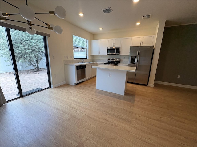 10586 W 33rd Ct Unit 10586, Hialeah, FL 33018 - kitchen featuring stainless steel appliances, light countertops, white cabinetry, light wood-style floors, and a kitchen island