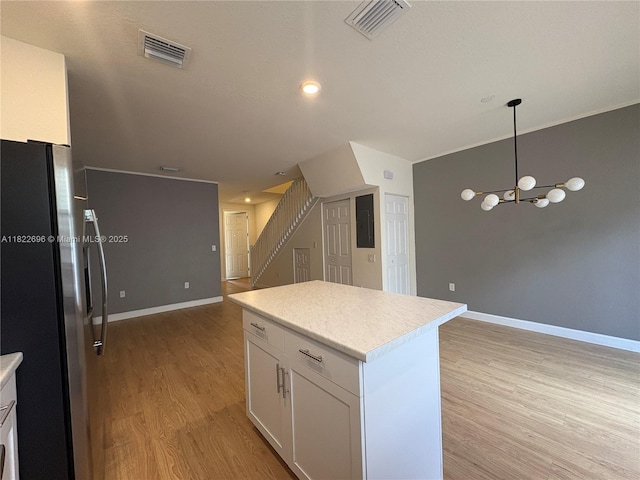 10586 W 33rd Ct Unit 10586, Hialeah, FL 33018 - kitchen featuring freestanding refrigerator, light wood finished floors, open floor plan, white cabinets, and light countertops