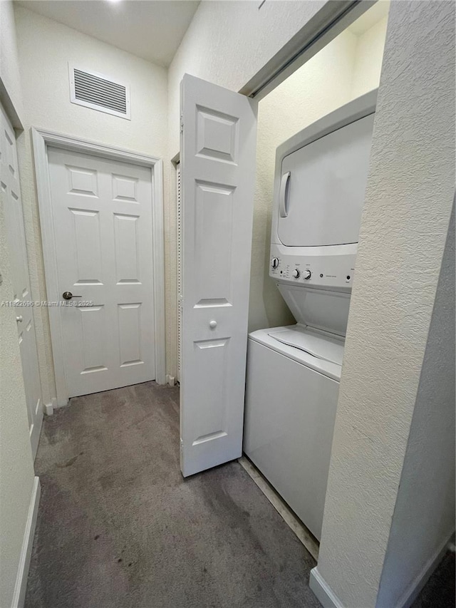 10586 W 33rd Ct Unit 10586, Hialeah, FL 33018 - laundry room with stacked washing machine and dryer, carpet, and a textured wall