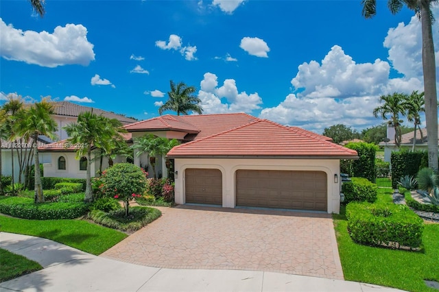 2489 Eagle Watch Ln, Weston, FL 33327 - mediterranean / spanish home with stucco siding, a tile roof, an attached garage, and decorative driveway