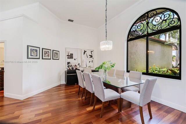 2489 Eagle Watch Ln, Weston, FL 33327 - dining area featuring a chandelier, wood finished floors, ornamental molding, a towering ceiling, and arched walkways