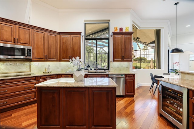 2489 Eagle Watch Ln, Weston, FL 33327 - kitchen with appliances with stainless steel finishes, beverage cooler, decorative light fixtures, dark wood finished floors, and light stone countertops