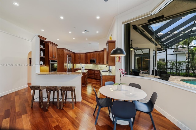 2489 Eagle Watch Ln, Weston, FL 33327 - dining area with dark wood-style floors, recessed lighting, and arched walkways