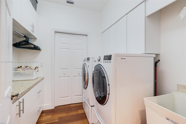 2489 Eagle Watch Ln, Weston, FL 33327 - laundry room featuring washing machine and dryer, wood finished floors, and cabinet space