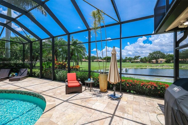2489 Eagle Watch Ln, Weston, FL 33327 - view of patio with grilling area, a water view, an outdoor pool, and a lanai