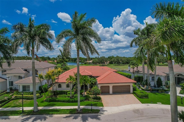 2489 Eagle Watch Ln, Weston, FL 33327 - mediterranean / spanish-style home featuring decorative driveway, a tiled roof, an attached garage, and a front lawn