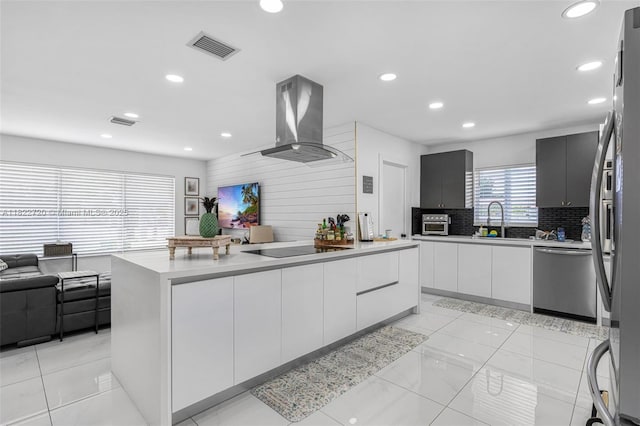 10371 SW 44th St, Miami, FL 33165 - kitchen with appliances with stainless steel finishes, island exhaust hood, modern cabinets, backsplash, and light countertops