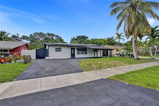 1772 SW 43rd Ave, Fort Lauderdale, FL 33317 - view of front of property featuring roof mounted solar panels, asphalt driveway, and a gate