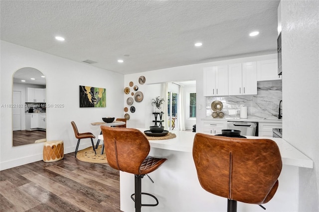 1772 SW 43rd Ave, Fort Lauderdale, FL 33317 - kitchen with a breakfast bar, white cabinetry, light countertops, tasteful backsplash, and recessed lighting