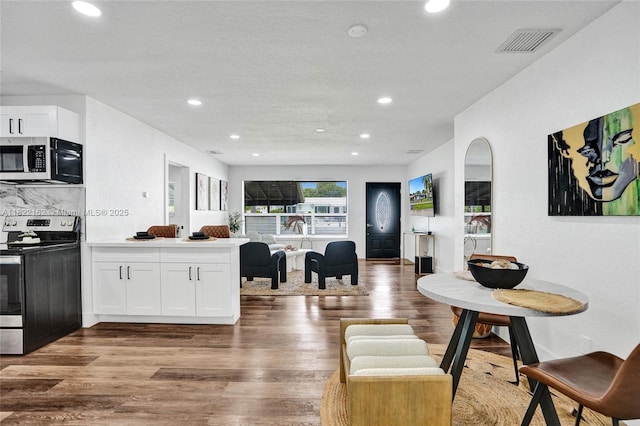 1772 SW 43rd Ave, Fort Lauderdale, FL 33317 - kitchen with appliances with stainless steel finishes, open floor plan, recessed lighting, white cabinets, and wood finished floors