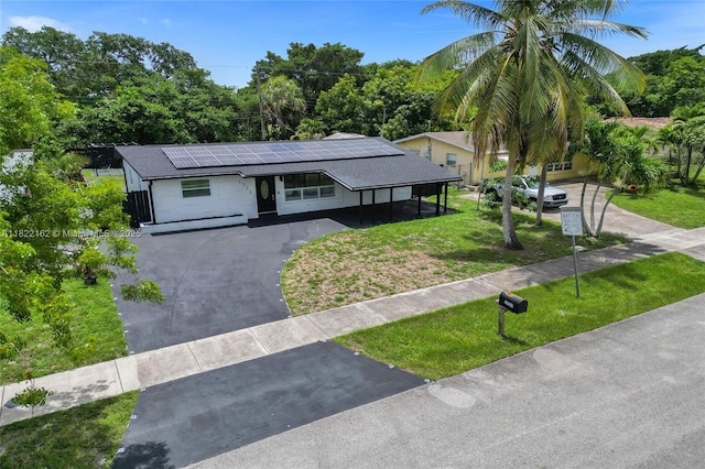 1772 SW 43rd Ave, Fort Lauderdale, FL 33317 - view of front of property with asphalt driveway, roof mounted solar panels, and a front lawn
