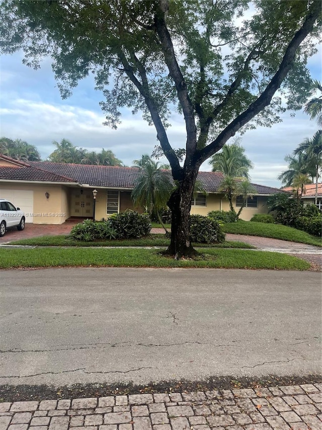 16120 E Troon Cir, Miami Lakes, FL 33014 - view of front of house with driveway, a tile roof, an attached garage, and stucco siding