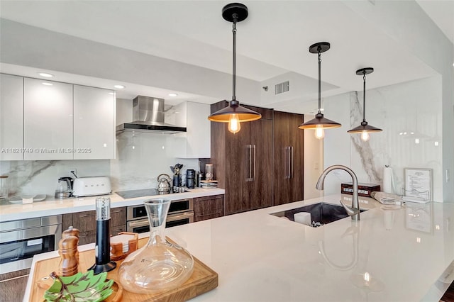 16425 Collins Ave Unit 311, Sunny Isles Beach, FL 33160 - kitchen with wall chimney range hood, modern cabinets, appliances with stainless steel finishes, light countertops, and recessed lighting