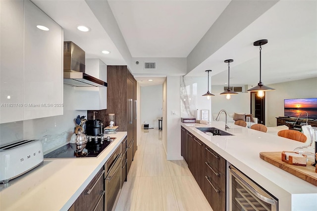 16425 Collins Ave Unit 311, Sunny Isles Beach, FL 33160 - kitchen with wall chimney range hood, modern cabinets, beverage cooler, black electric cooktop, and recessed lighting