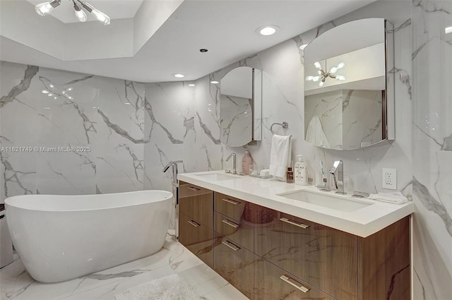 16425 Collins Ave Unit 311, Sunny Isles Beach, FL 33160 - bathroom with double vanity, marble tiled floors, a freestanding tub, stone wall, and recessed lighting