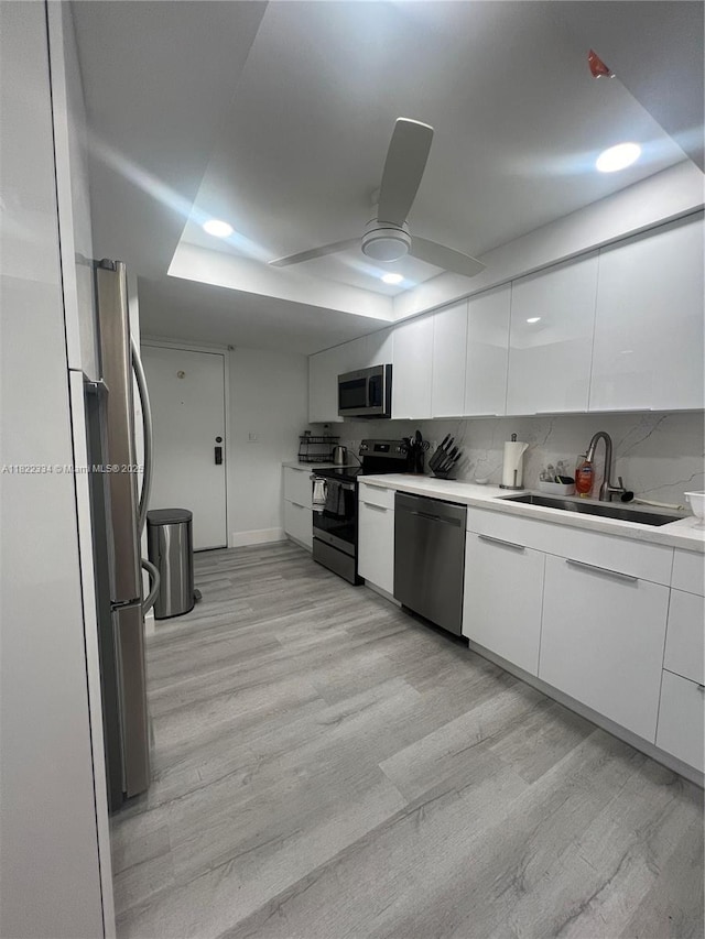 4900 N Ocean Blvd Unit 212, Lauderdale By The Sea, FL 33308 - kitchen with appliances with stainless steel finishes, white cabinets, light wood-style flooring, and modern cabinets