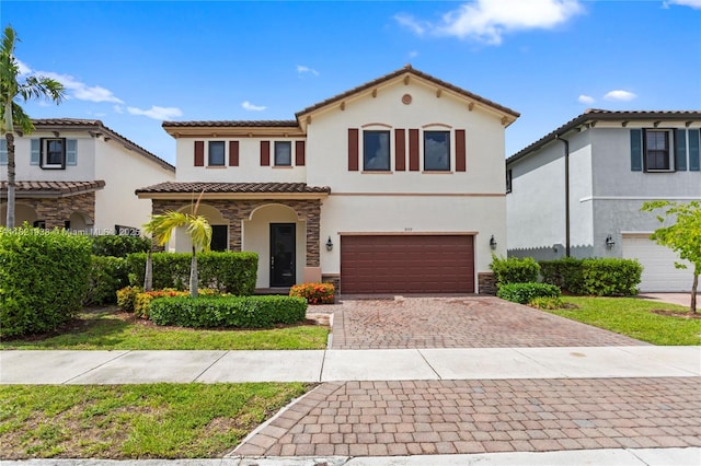 3557 W 94th Ter, Hialeah, FL 33018 - mediterranean / spanish house with stucco siding, a garage, decorative driveway, a tiled roof, and stone siding