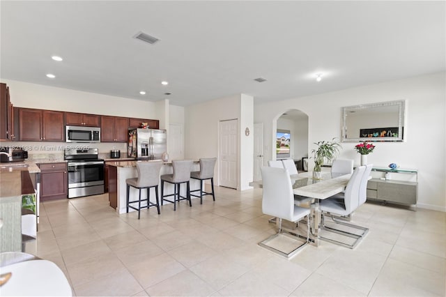 3557 W 94th Ter, Hialeah, FL 33018 - dining space featuring arched walkways, recessed lighting, and light tile patterned floors