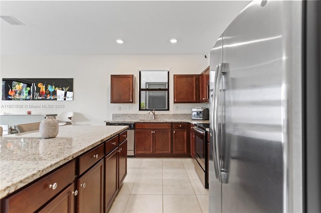 3557 W 94th Ter, Hialeah, FL 33018 - kitchen with stainless steel appliances, light tile patterned flooring, light stone counters, and recessed lighting