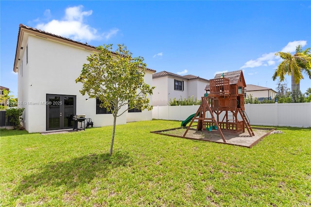 3557 W 94th Ter, Hialeah, FL 33018 - rear view of property featuring a playground, stucco siding, and a fenced backyard