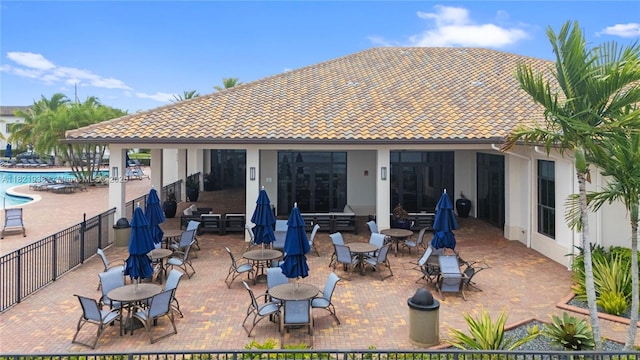 3557 W 94th Ter, Hialeah, FL 33018 - back of property featuring stucco siding, a tiled roof, a community pool, and a patio