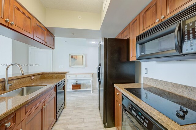 347 N New River Dr E Unit 1505, Fort Lauderdale, FL 33301 - kitchen featuring black appliances, brown cabinets, and light stone counters
