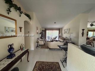 126 Chestnut Cir, Royal Palm Beach, FL 33411 - hallway with healthy amount of natural light, lofted ceiling, and arched walkways