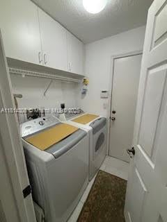 126 Chestnut Cir, Royal Palm Beach, FL 33411 - laundry area featuring washing machine and dryer and cabinet space