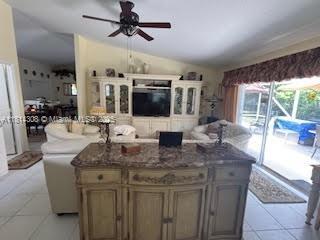 126 Chestnut Cir, Royal Palm Beach, FL 33411 - kitchen with a ceiling fan, a center island, light tile patterned flooring, and vaulted ceiling