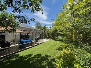 126 Chestnut Cir, Royal Palm Beach, FL 33411 - view of green lawn with a lanai