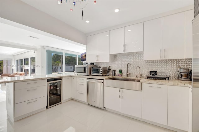 11230 SW 69th Ct, Pinecrest, FL 33156 - kitchen with wine cooler, stainless steel appliances, a peninsula, tasteful backsplash, and recessed lighting