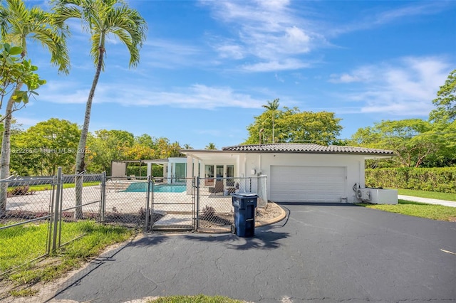 11230 SW 69th Ct, Pinecrest, FL 33156 - view of front of property featuring driveway, stucco siding, an attached garage, a gate, and a tile roof