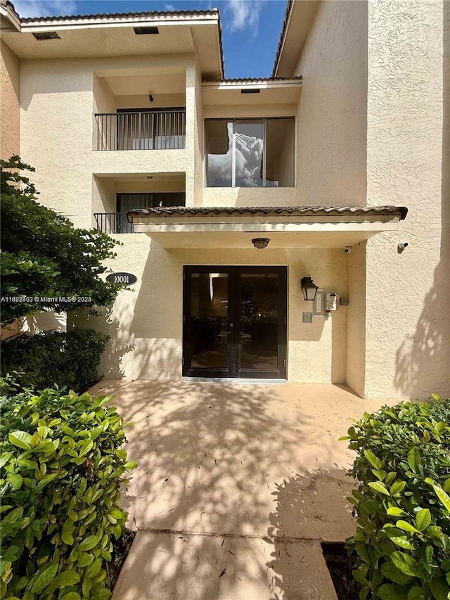 10001 W Atlantic Blvd Unit 321, Coral Springs, FL 33071 - entrance to property with french doors, stucco siding, and a tiled roof
