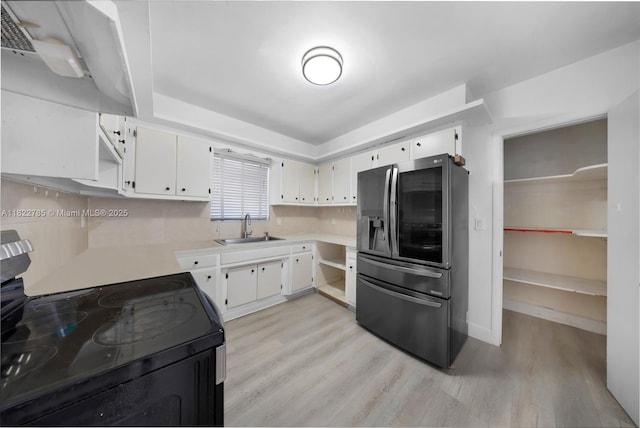 5781 SW 25th St, Miami, FL 33155 - kitchen with stainless steel refrigerator with ice dispenser, black range with electric stovetop, light wood finished floors, light countertops, and extractor fan