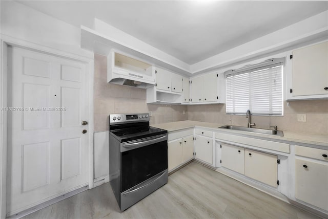 5781 SW 25th St, Miami, FL 33155 - kitchen featuring stainless steel range with electric cooktop, under cabinet range hood, light countertops, light wood-style flooring, and decorative backsplash