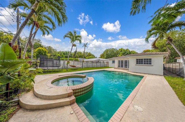 5781 SW 25th St, Miami, FL 33155 - view of pool featuring french doors, a trampoline, a pool with connected hot tub, a fenced backyard, and a patio area