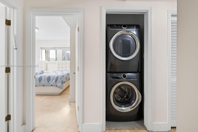 1601 Bay Rd Unit 4, Miami Beach, FL 33139 - washroom with stacked washer / dryer and light tile patterned floors
