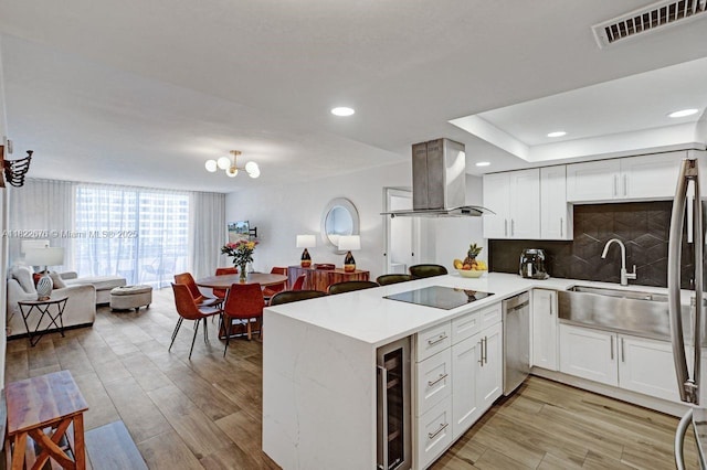 600 Three Islands Blvd Unit 615, Hallandale Beach, FL 33009 - kitchen featuring open floor plan, wall chimney exhaust hood, stainless steel dishwasher, wine cooler, and a peninsula