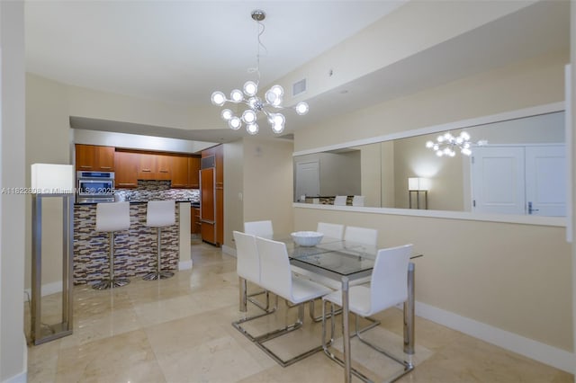 3101 S Ocean Dr Unit 404, Hollywood, FL 33019 - dining space featuring a chandelier and baseboards