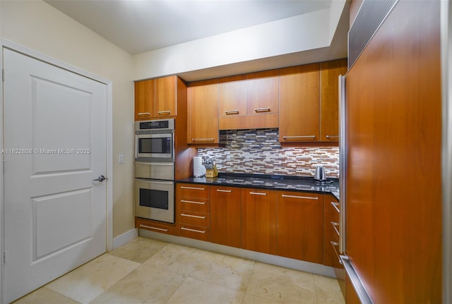 3101 S Ocean Dr Unit 404, Hollywood, FL 33019 - kitchen with stainless steel oven, paneled built in fridge, tasteful backsplash, dark countertops, and brown cabinetry