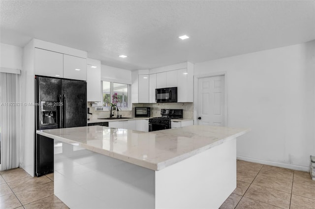 27645 SW 163rd Ave, Homestead, FL 33031 - kitchen featuring black appliances, modern cabinets, white cabinets, tasteful backsplash, and a textured ceiling