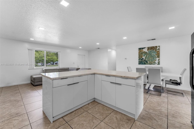 27645 SW 163rd Ave, Homestead, FL 33031 - kitchen featuring open floor plan, white cabinetry, recessed lighting, light tile patterned flooring, and a textured ceiling